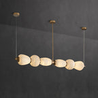 Clérachic Pebble chandelier photographed against charcoal, each stone form lit from within.