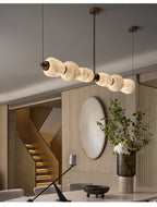 Clérachic Pebble chandelier above an entrance hall with a curved staircase and oval mirror.