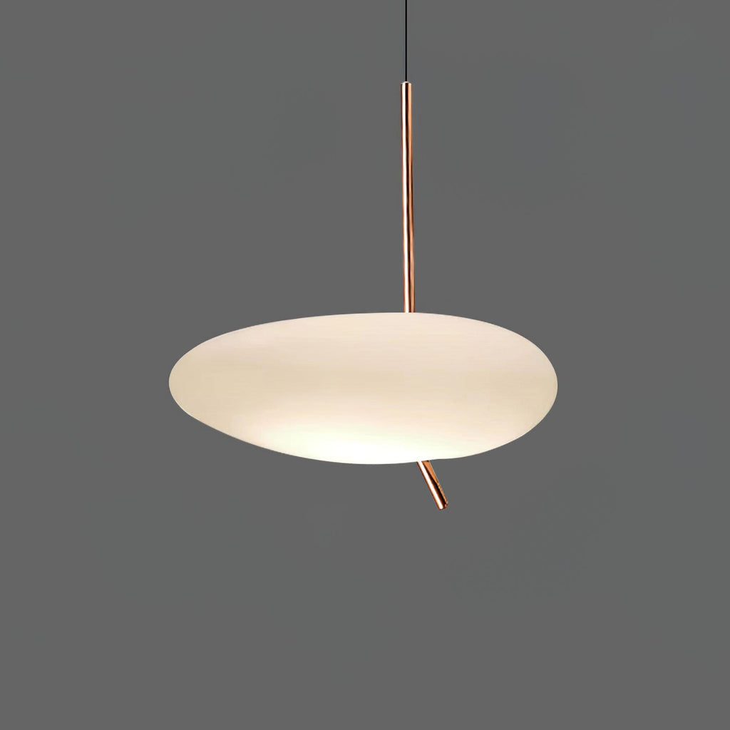 Clérachic pebble pendant glowing softly against a dark gray backdrop, its rose gold stem and angled tip clearly visible.