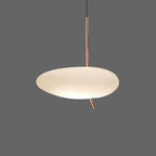 Clérachic pebble pendant glowing softly against a dark gray backdrop, its rose gold stem and angled tip clearly visible.