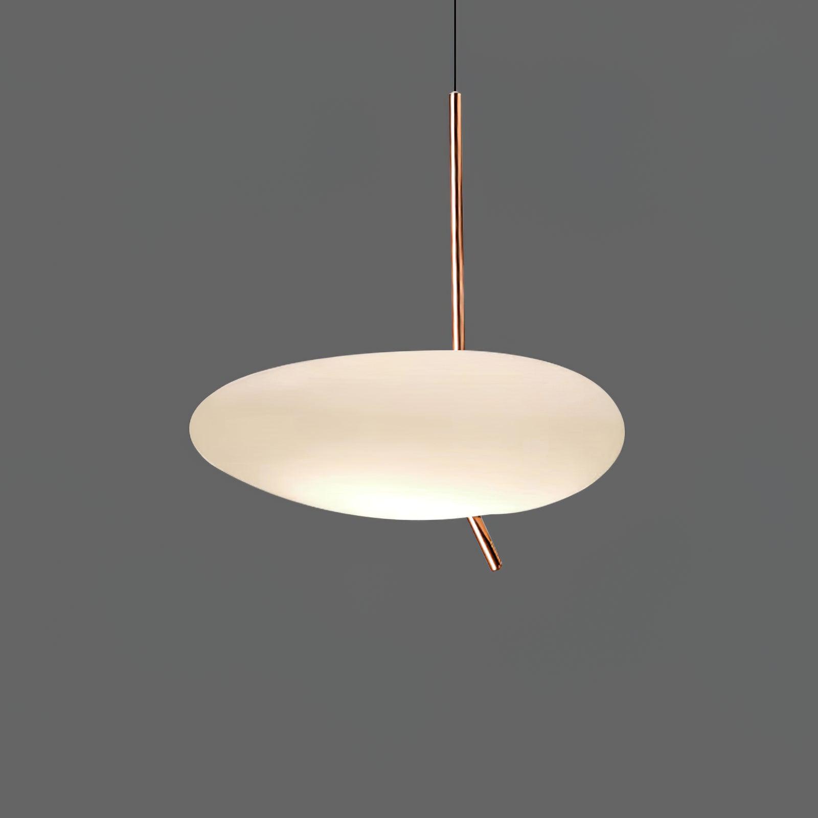 Clérachic pebble pendant glowing softly against a dark gray backdrop, its rose gold stem and angled tip clearly visible.