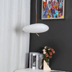 Clérachic pendant hanging beside a sheer curtain, with a colorful painting and rose vase on the nightstand below.