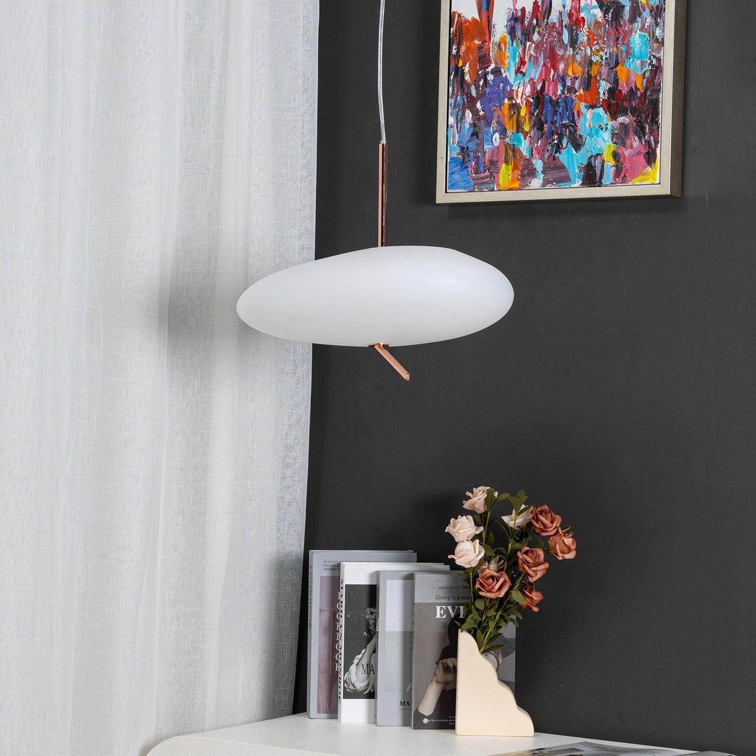 Clérachic pendant hanging beside a sheer curtain, with a colorful painting and rose vase on the nightstand below.