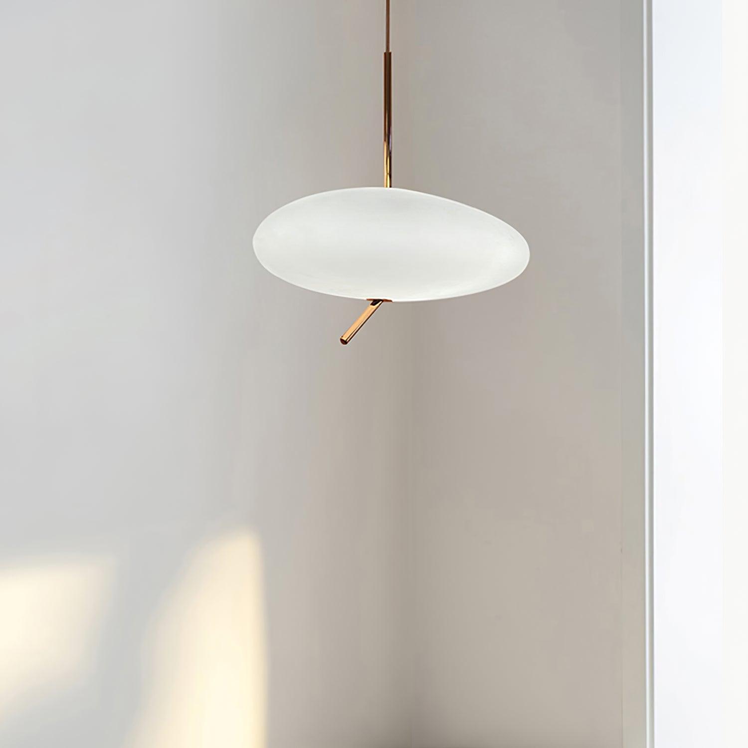 Clérachic pebble pendant photographed unlit in a plain gray studio corner, showing the frosted shade's shape.
