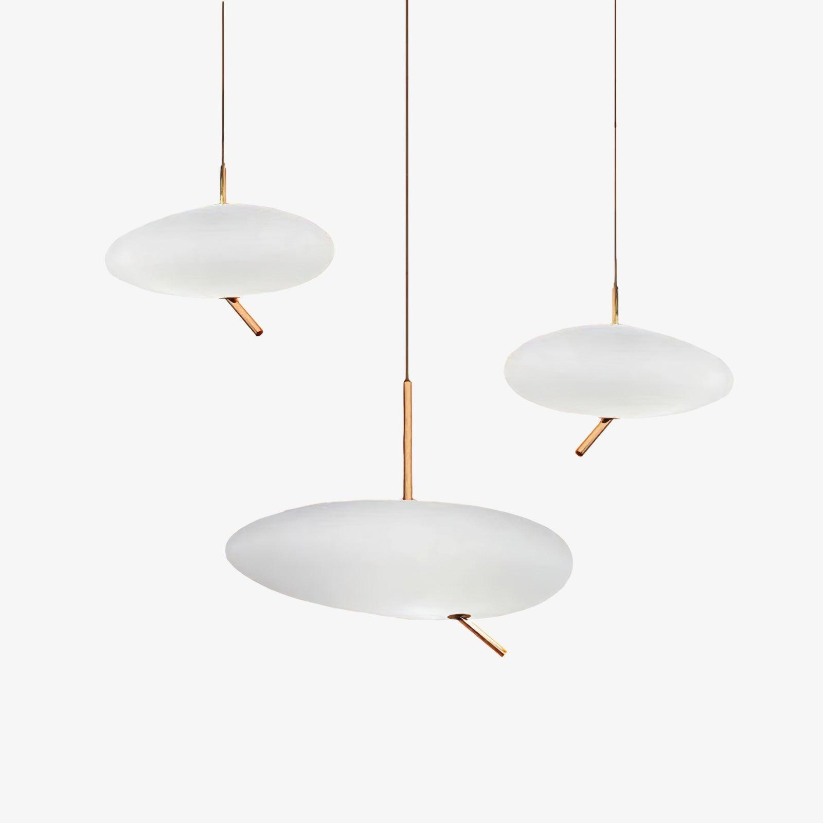 Three Clérachic pebble pendants shown unlit and grouped on white, echoing the trio's staggered arrangement.