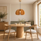 Clérachic dome pendant of vertical wood slats lit above a round table, with cream chairs, a sage bench seat and a small cabinet.