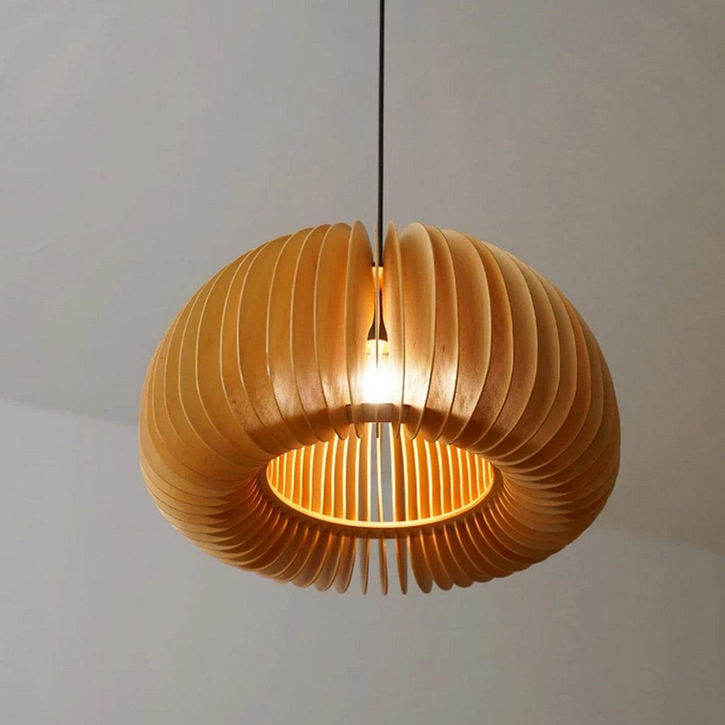 Looking up at the open centre of this Clérachic wooden pendant, with its curled slats glowing around the bulb against a pale wall.