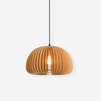 Clérachic slat pendant in natural wood on a pale grey-white backdrop, with its slats evenly spaced around a lit bulb.