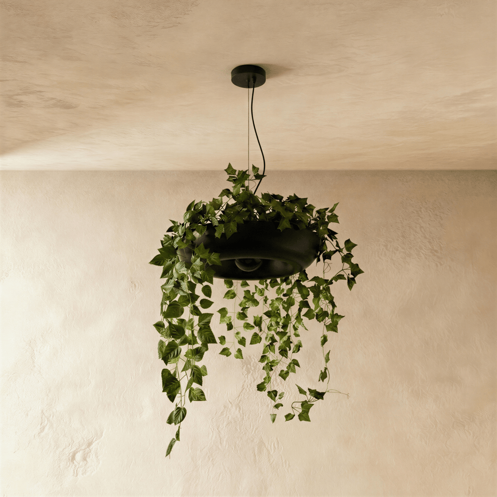 Clérachic black planter-style pendant, unlit, with artificial ivy spilling over its rim and hanging below on a black cord.