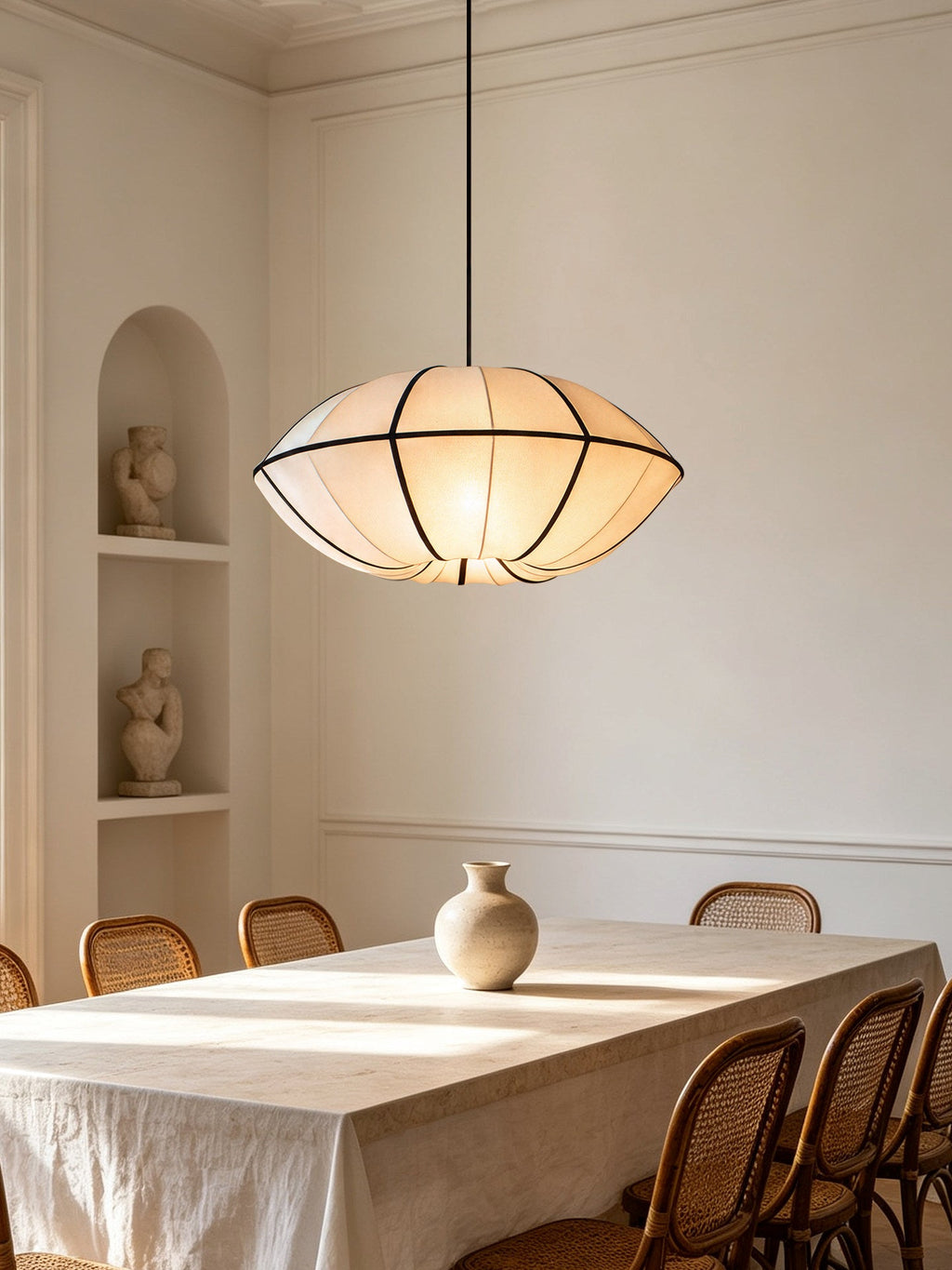 This Clérachic pendant's wide dome shade lights a dining table set beneath an arched alcove.
