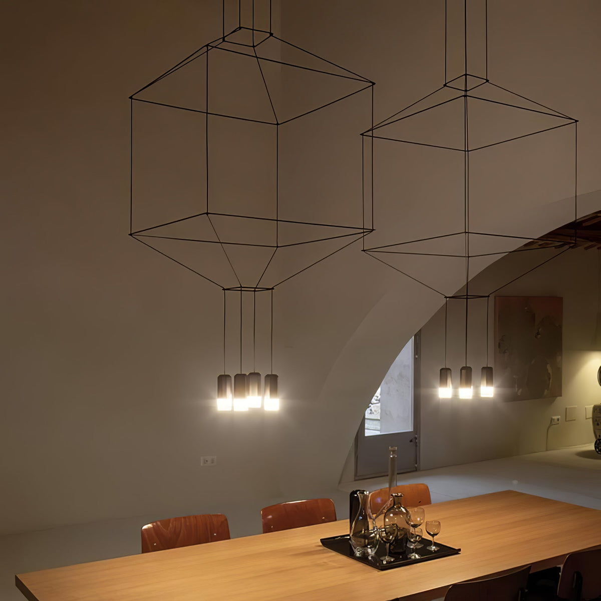 Square and octagonal cable-frame pendants light up above a long oak dining table, from Clérachic.