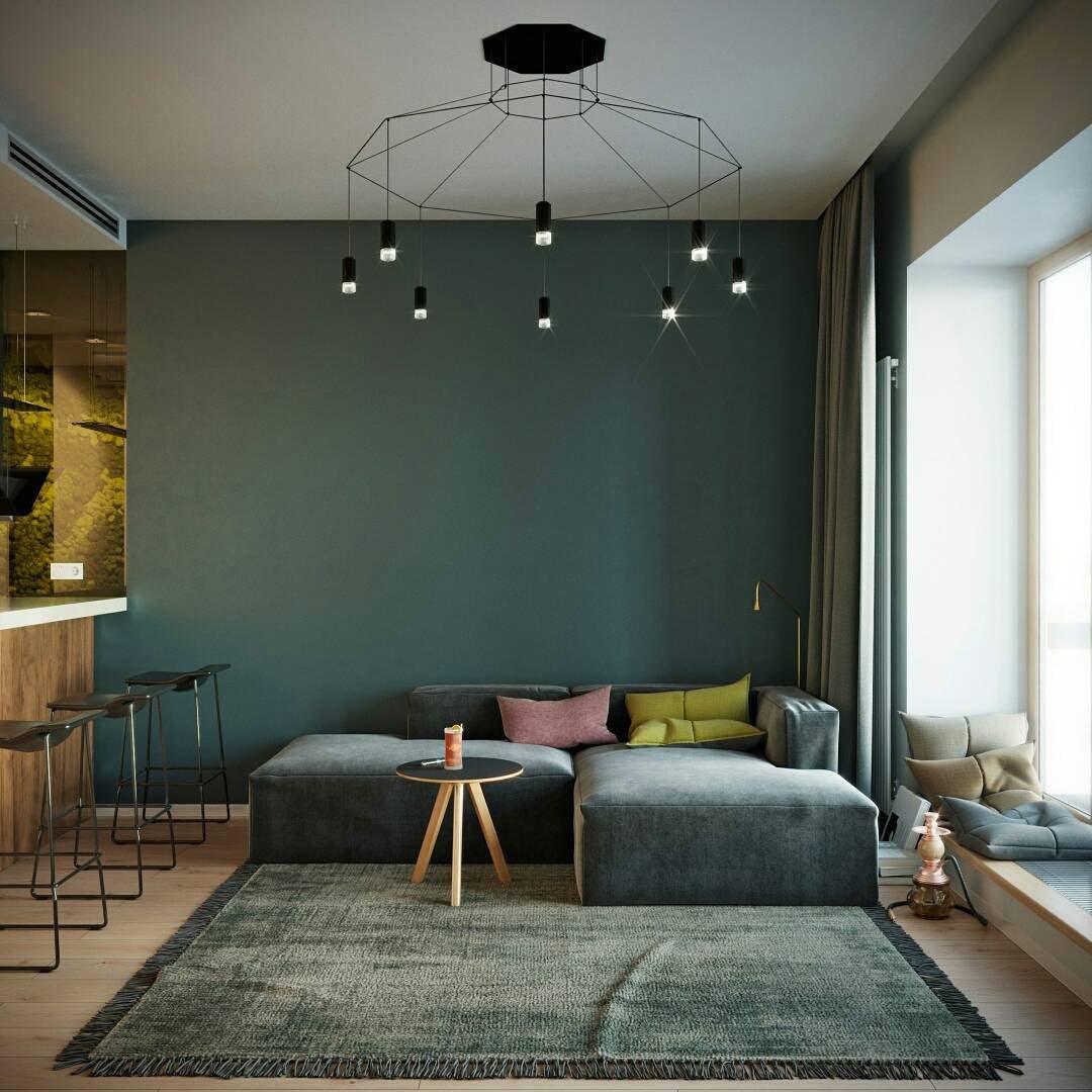 Wide black wireframe pendant with a canopy and small lights spreading across a teal living room, from Clérachic.
