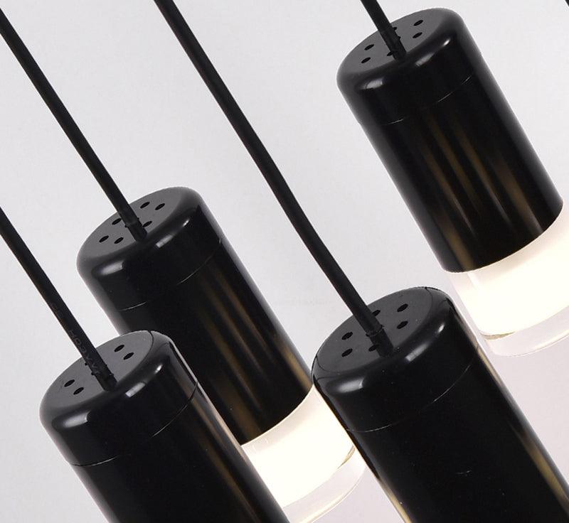 Close view of black cylindrical light heads with perforated caps and frosted diffusers, on this Clérachic pendant.