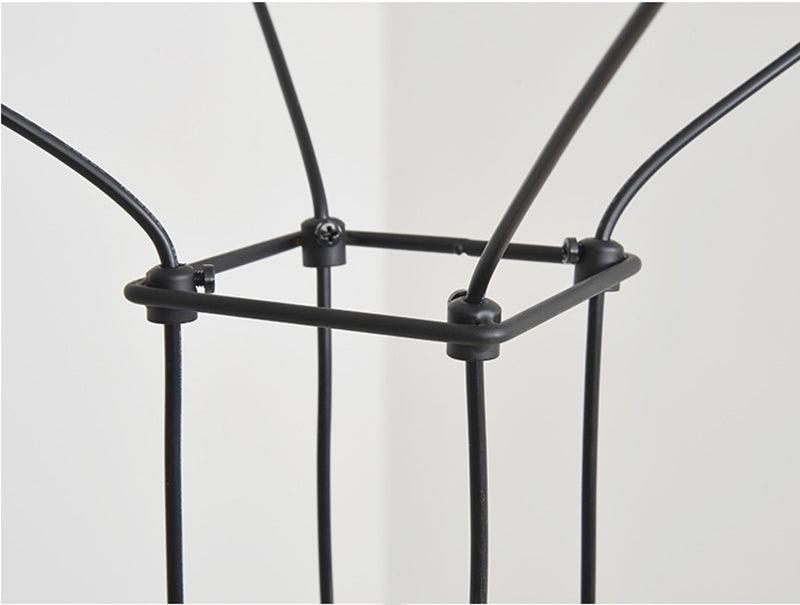 Close view of a cable joint where the black wires meet at a square frame corner on this Clérachic pendant.