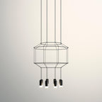 Octagonal two-tier wireframe pendant with four black light heads below, on a warm cream backdrop, from Clérachic.