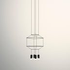 Small cable-frame pendant with a squat cage and three black light heads below, on a cream backdrop, from Clérachic.