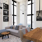 Cube wireframe pendant in a tall living room with a grey sofa, black-framed windows and framed prints, from Clérachic.
