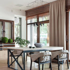 Wireframe pendant above a dining table with quilted chairs, beside a window with a beige curtain, from Clérachic.