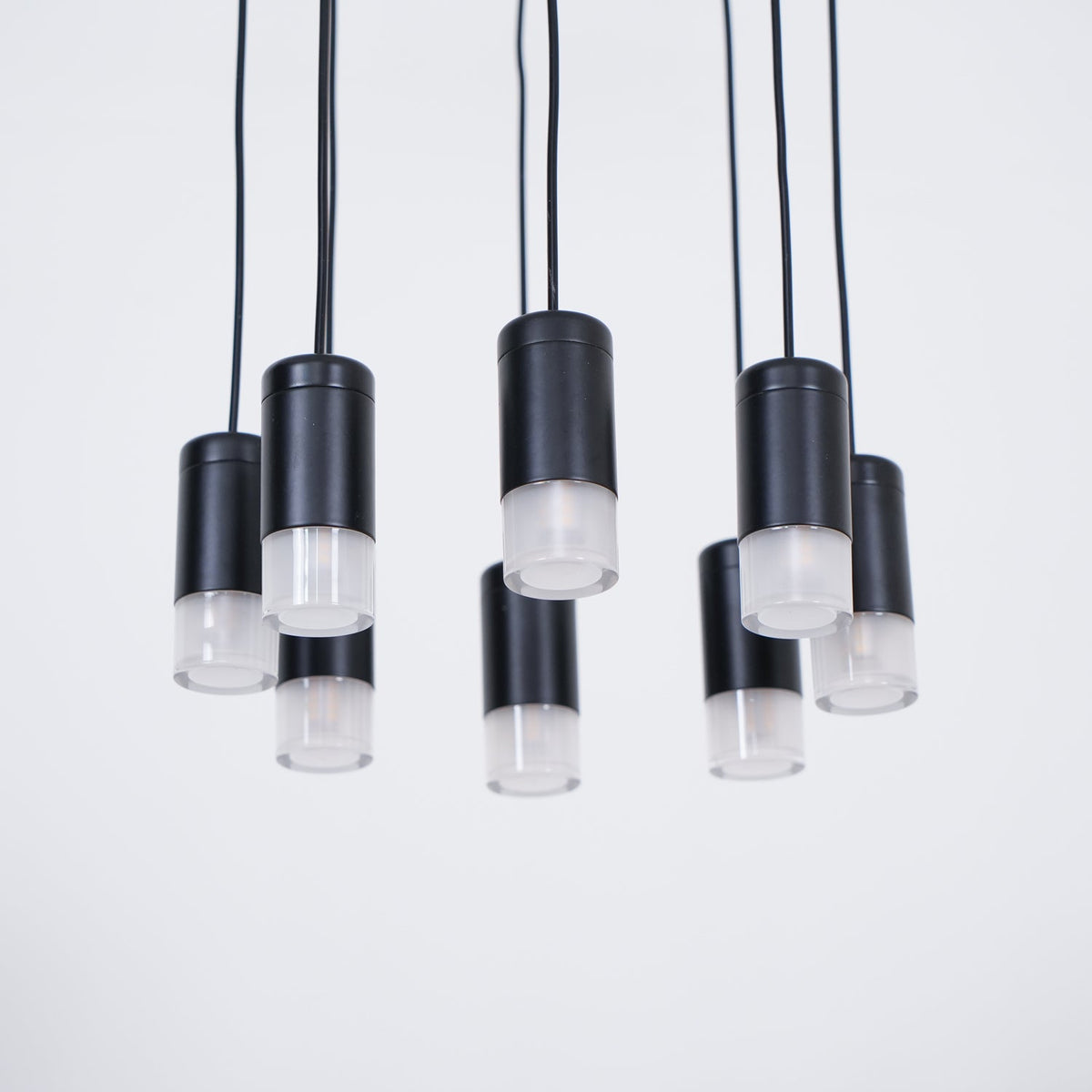 Underside view of the black light heads with frosted diffusers hanging at different lengths on this Clérachic pendant.