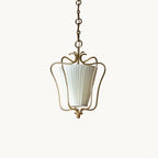 Clérachic brass lantern pendant with a vertically pleated white fabric shade inside a curled wire frame, on a plain white backdrop.