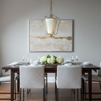Clérachic pendant with a pleated shade above a dark dining table with grey chairs, in front of a large abstract canvas.