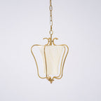 Clérachic brass pendant with a cream twisted-pleat shade and a curled crown, on a pale lilac-grey backdrop.