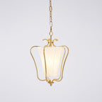 Clérachic pendant with a lit diagonally pleated shade inside the brass frame, on a pale lilac-grey backdrop.