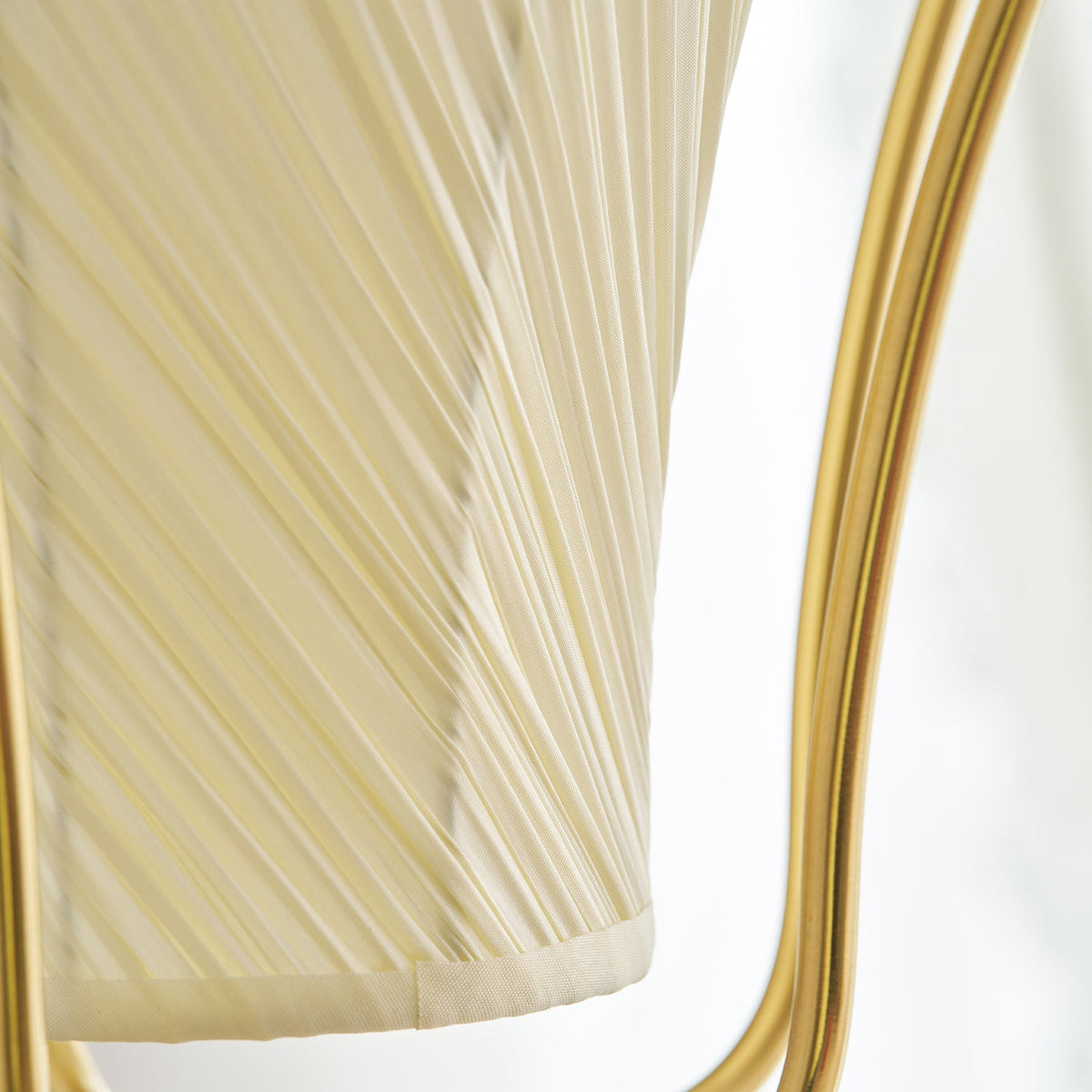 Close view of the fine diagonal pleats on the fabric shade of this Clérachic pendant, beside the brass frame.
