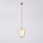 Clérachic pendant on its slim brass chain and ceiling canopy, with a twisted-pleat shade, on a pale backdrop.