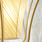 Close view of the glowing, finely twisted pleats of the shade on this Clérachic pendant, held by the brass frame.