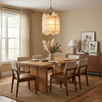 Over a walnut dining table with cream upholstered chairs, this Clérachic pendant glows warm and inviting.