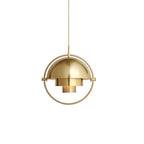 Gold-toned Clérachic pendant with a round frame and stepped shade layers, cut out on a plain white backdrop.