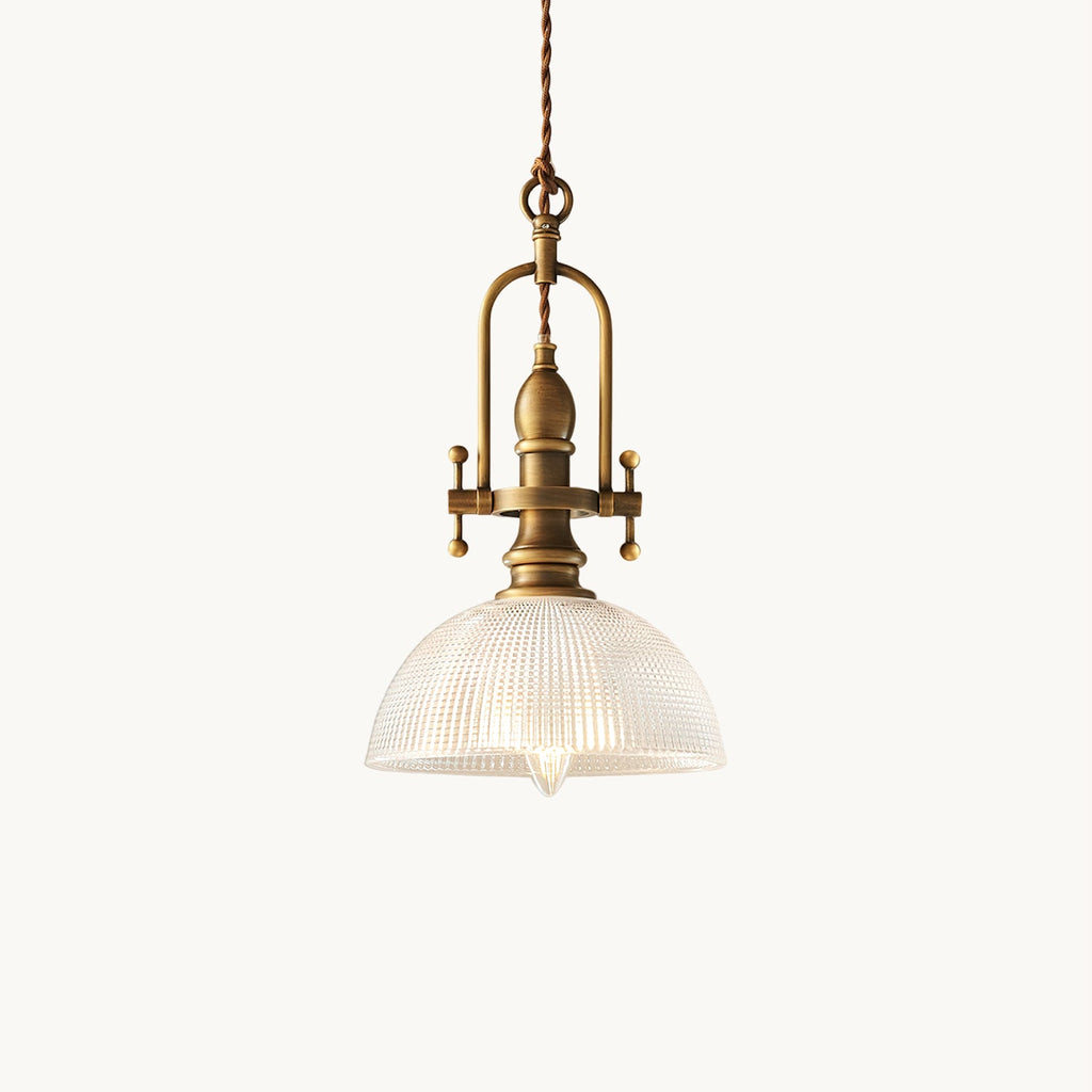 This Clérachic pendant light on a plain white backdrop, with a ribbed clear glass dome, antique brass fittings and a twisted cord.