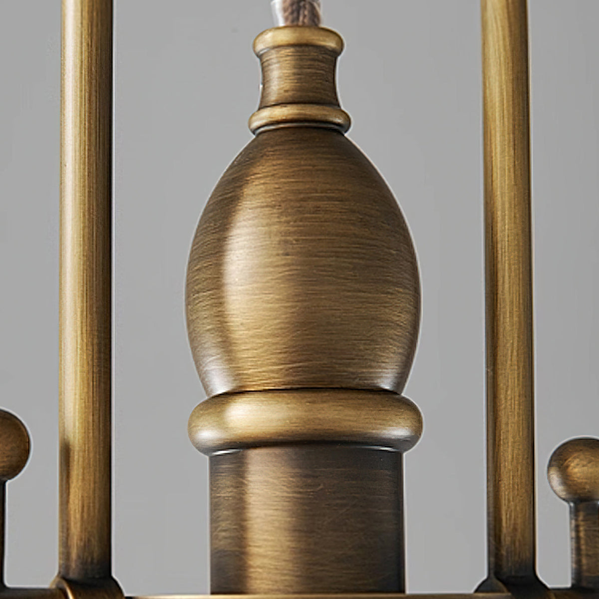 Close view of the antique brass finial and the cylindrical collar on this Clérachic pendant, with fine brushed marks.