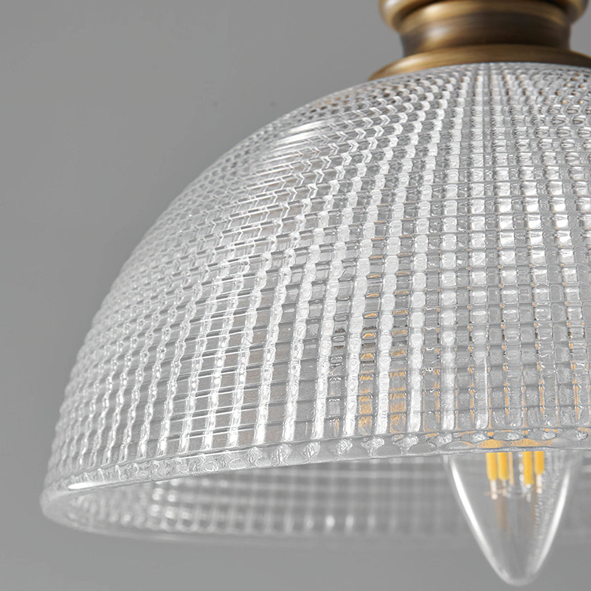 Close view of the ribbed glass dome on this Clérachic pendant, showing a candle-shaped filament bulb inside.