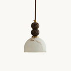 Dome-shaped faux alabaster shade under two dark marble spheres on this Clérachic pendant light, shown on a plain white backdrop.