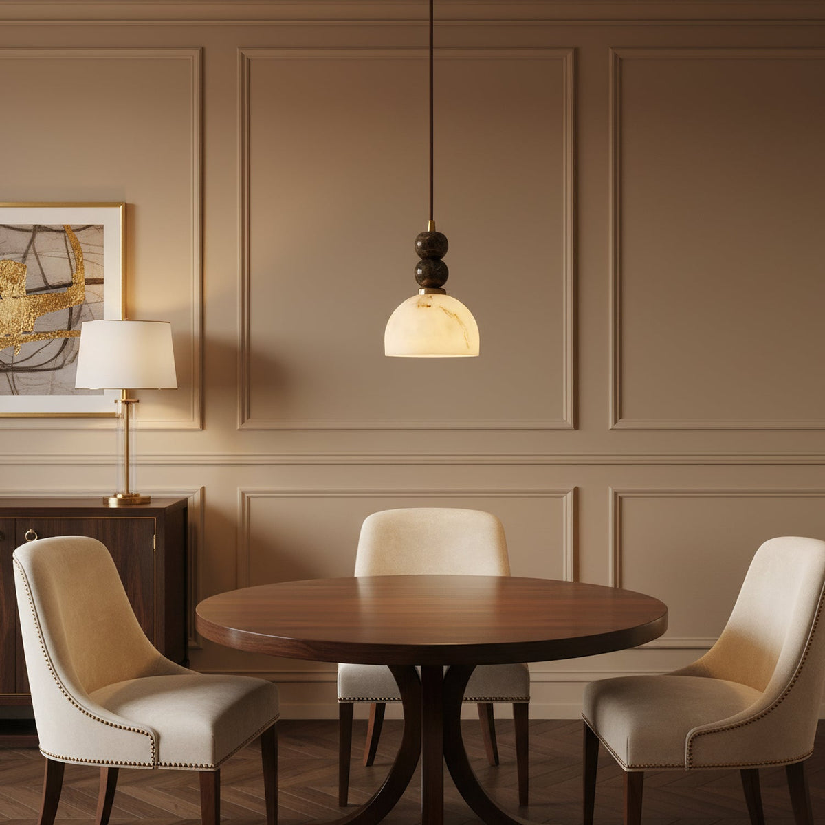 A lit Clérachic pendant light hangs over a round walnut table in a room with taupe panelled walls and cream dining chairs.