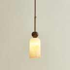This Clérachic pendant light glows softly through its rounded cylinder shade, with a single marble sphere and a brass rod above.
