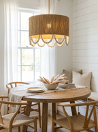 Above a round wood table with wishbone chairs, this Clérachic pendant glows in a shiplap-walled dining nook.