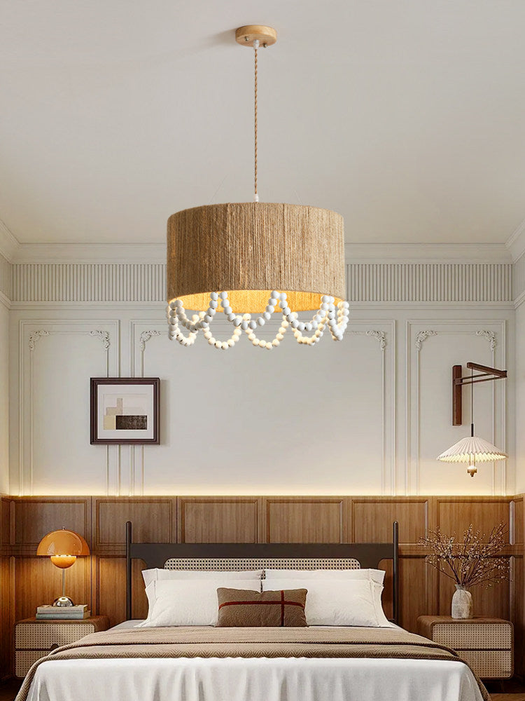 Beside a wood-panelled wall and matching bed frame, this Clérachic pendant lights a warm bedroom corner.