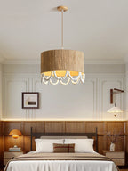 Beside a wood-panelled wall and matching bed frame, this Clérachic pendant lights a warm bedroom corner.