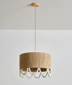 Full-drop studio shot of this Clérachic pendant, the beaded fringe swaying beneath a lit hemp rope shade.