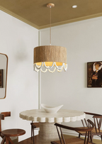 Above a round pedestal dining table beneath a gold-toned ceiling, this Clérachic pendant glows near a wall mirror.