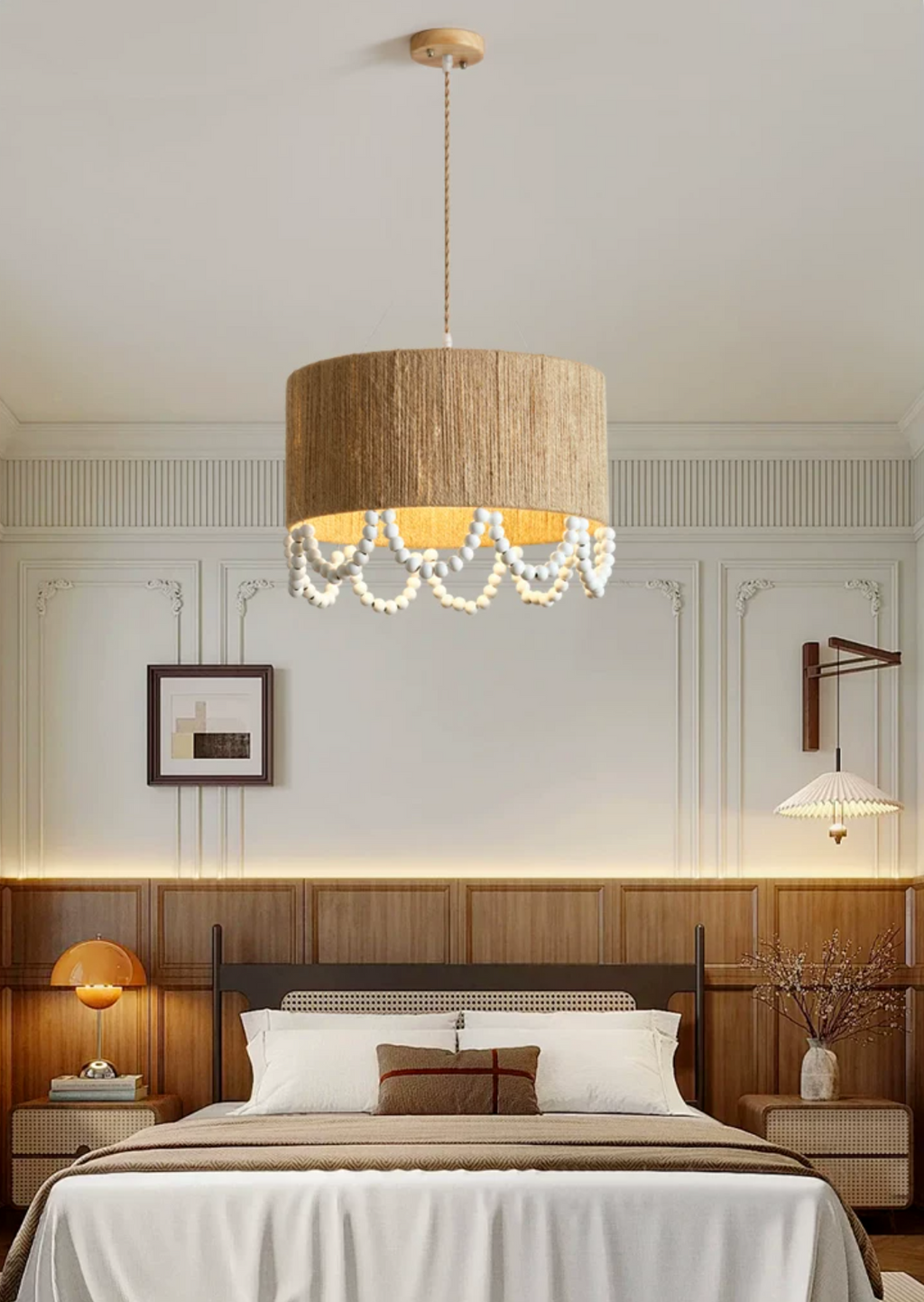 Beside a panelled headboard wall with a lit sconce, this Clérachic pendant glows above a striped-linen bed.