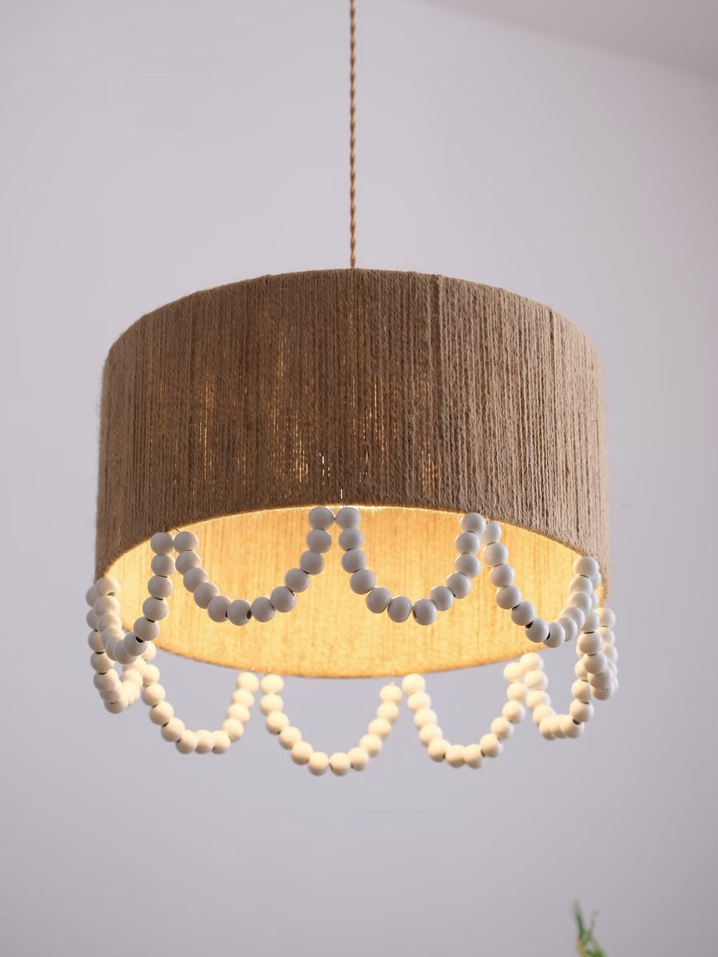 A darker brown version of this Clérachic pendant, its rope shade and grey beads shown on a plain backdrop.