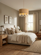 Beside a curtained window and a leather armchair, this Clérachic pendant lights a neutral bedroom in soft daylight.