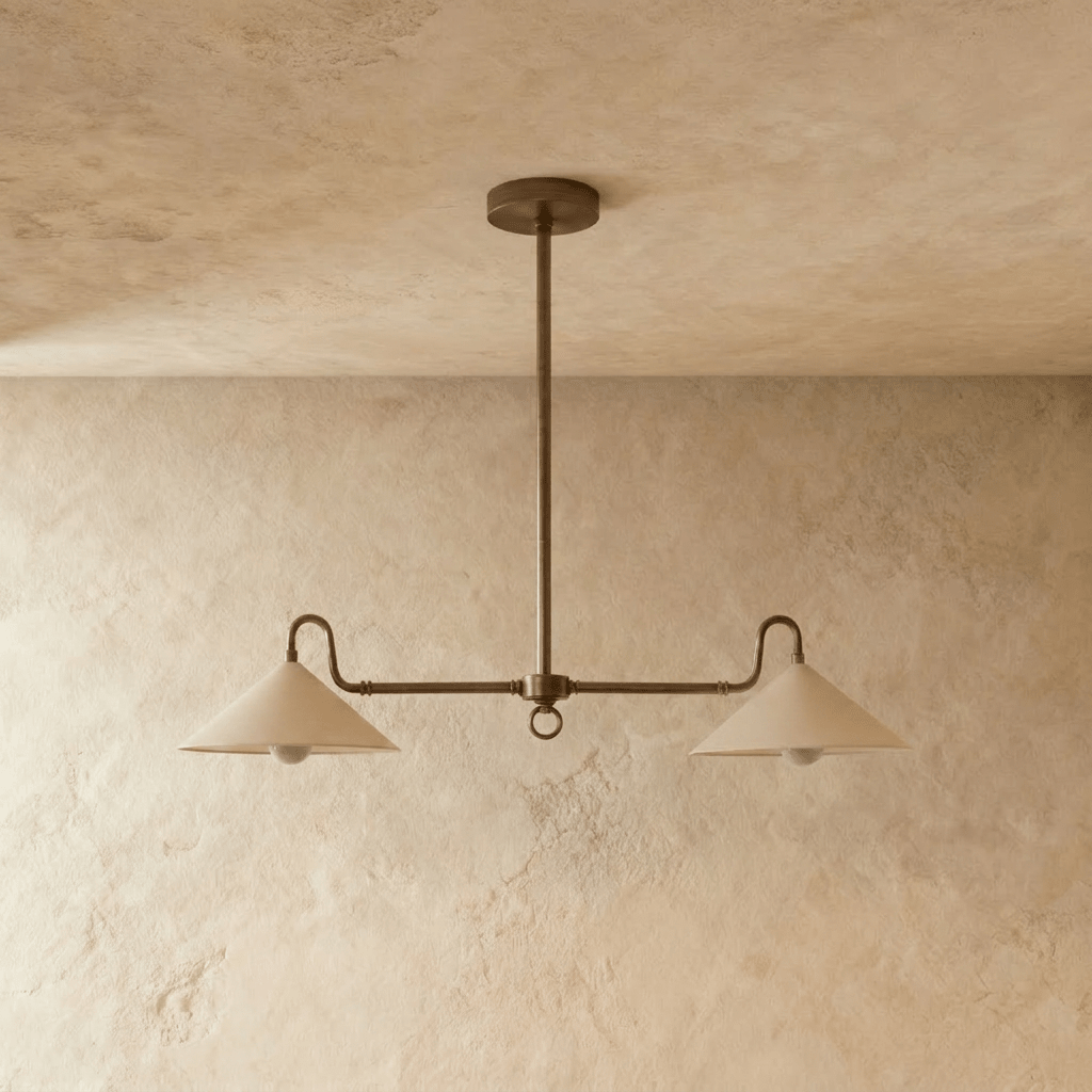This vintage brass Clérachic pendant light spans two cone shades, seen from a slightly angled ceiling view.
