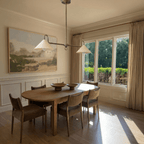 This chrome Clérachic pendant light hangs above an oval dining table beneath a framed landscape painting.