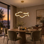 Round Clérachic pendant lit above a round wood table with olive velvet chairs, with a sunset view through a tall window.