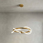 A round Clérachic wave pendant lit against a grey plaster wall, with a brass canopy and two fine suspension wires.